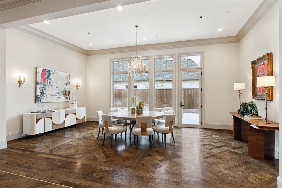 Host unforgettable gatherings in this elegant formal dining room, illuminated by a stunning designer chandelier. Positioned just off the entry gallery, this spacious area is bathed in natural light from expansive windows and features intricate hardwood flooring that adds timeless sophistication.