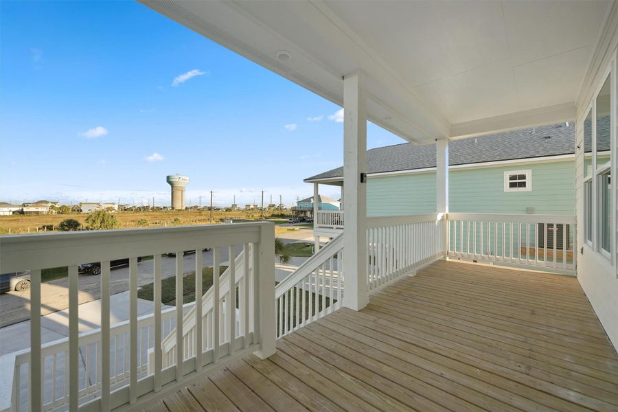 Private covered balcony overlooking green space and neighboring elevated coastal homes. Private covered balcony overlooking green space and neighboring elevated coastal homes.