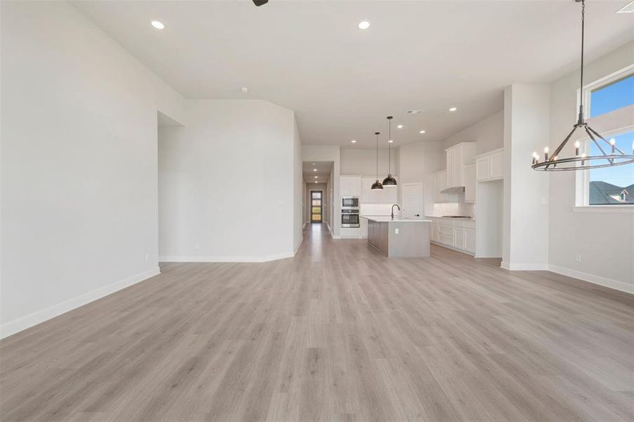 Expansive main living area featuring wood-finish flooring, recessed lighting, and a large window