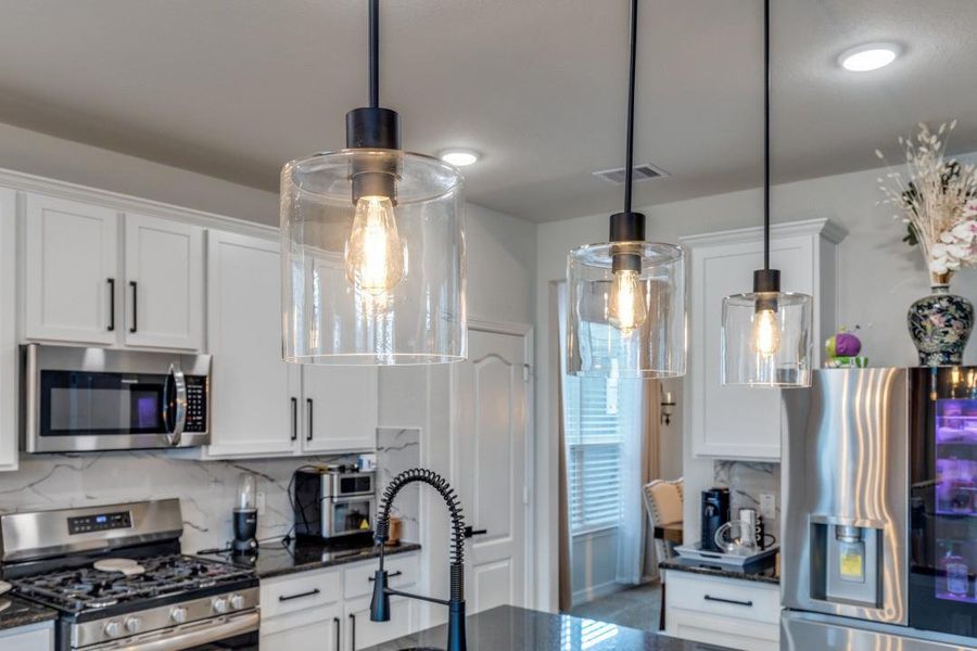 Features a gas cooktop, built-in microwave, and a contemporary faucet. Bright and inviting space.