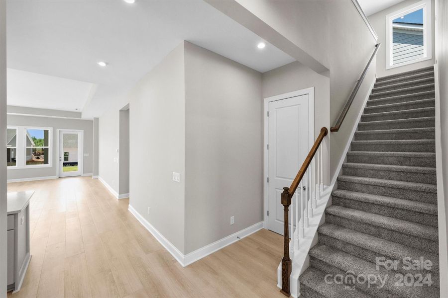 Foyer with EVP Flooring and Carpeted Staircase