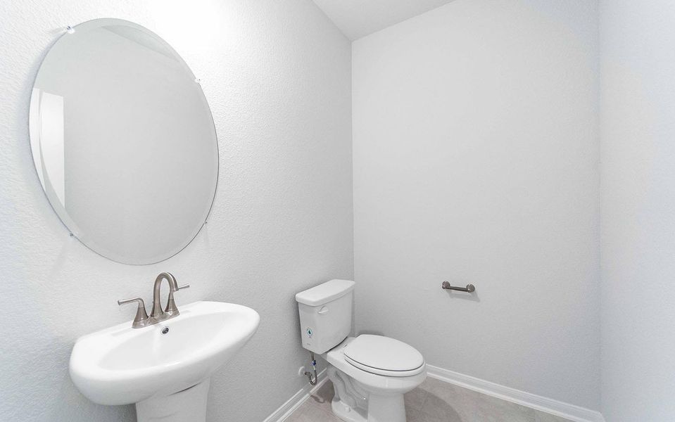 Half bath with tile patterned floors and a textured wall