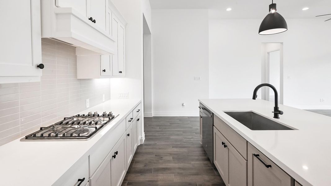 Kitchen with a sink, appliances with stainless steel finishes, light countertops, decorative backsplash, and recessed lighting