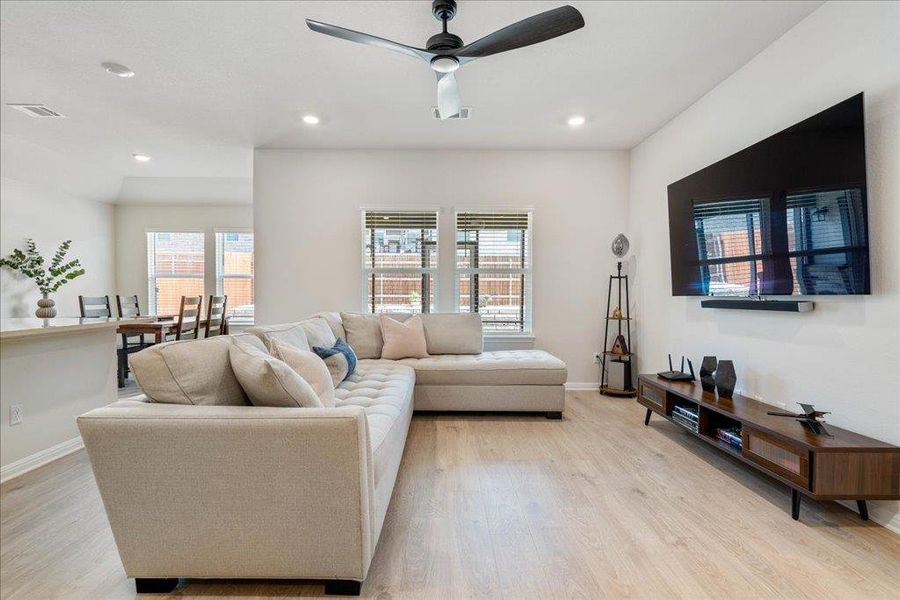 Living area with a ceiling fan, light wood-type flooring, baseboards, visible vents, and recessed lighting