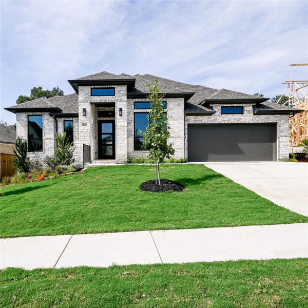 Prairie-style house with brick siding, a shingled roof, concrete driveway, and a garage