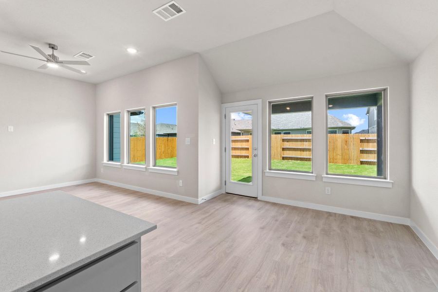 A well-lit living space with wide windows offers views of the verdant backyard.