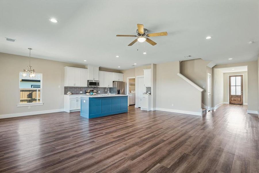 Kitchen with white cabinets, stainless steel appliances, a wealth of natural light, and dark wood-type flooring Kitchen with white cabinets, stainless steel appliances, a wealth of natural light, and dark wood-type flooring