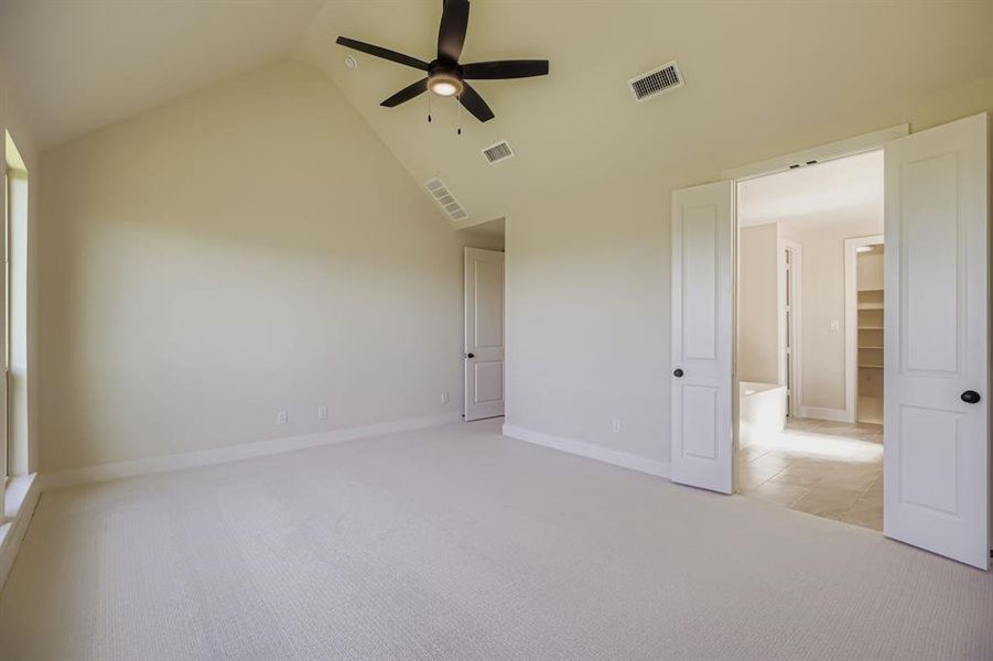 Unfurnished bedroom featuring light colored carpet, high vaulted ceiling, and ceiling fan