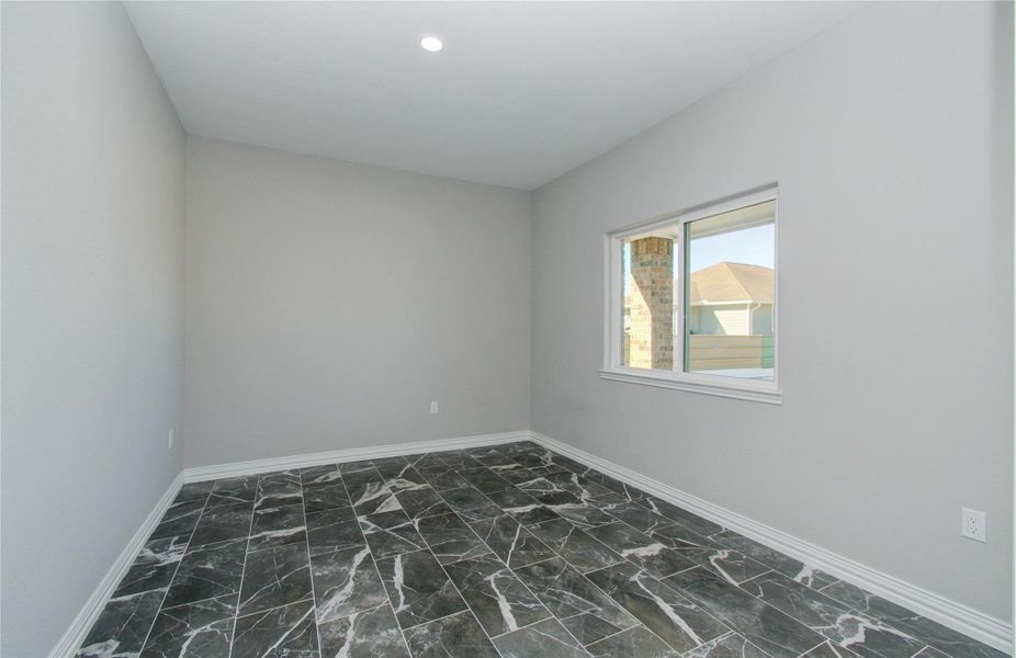 This room features sleek gray walls, a recessed ceiling light, and a window allowing natural light. The polished black and white marble floor adds a touch of elegance.