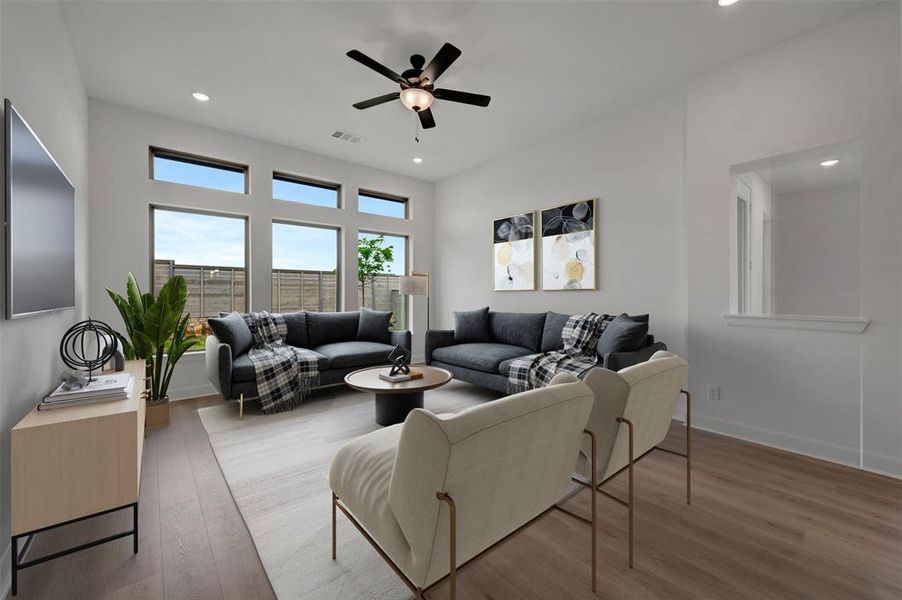 The property features an open-concept living area with large windows providing natural light, recessed lighting, and a ceiling fan