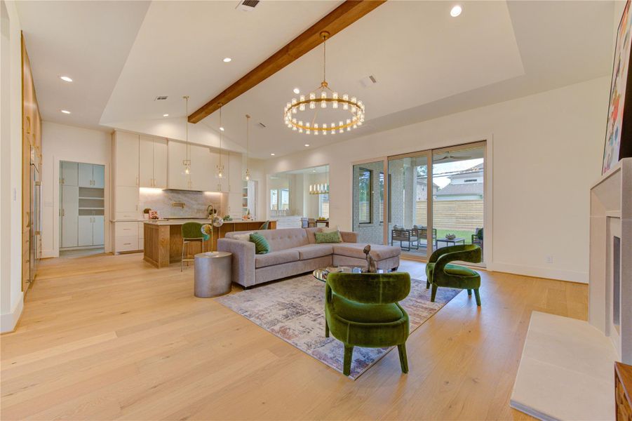 The heart of the home features an open-concept living space with soaring ceilings, exposed beams, and designer lighting.