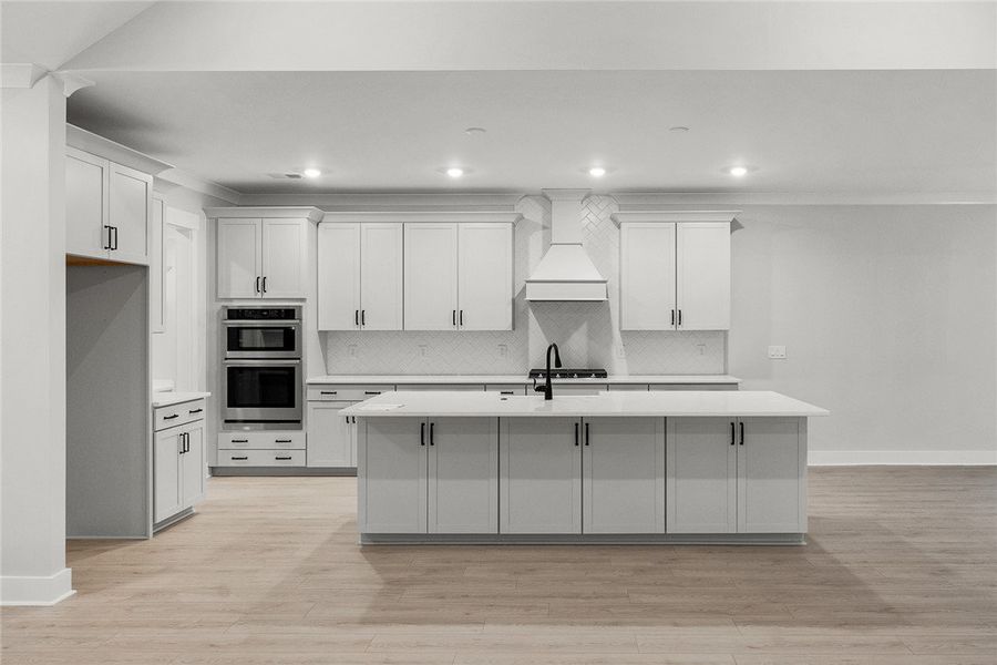 White cabinetry and light wood flooring define thi White cabinetry and light wood flooring define thi