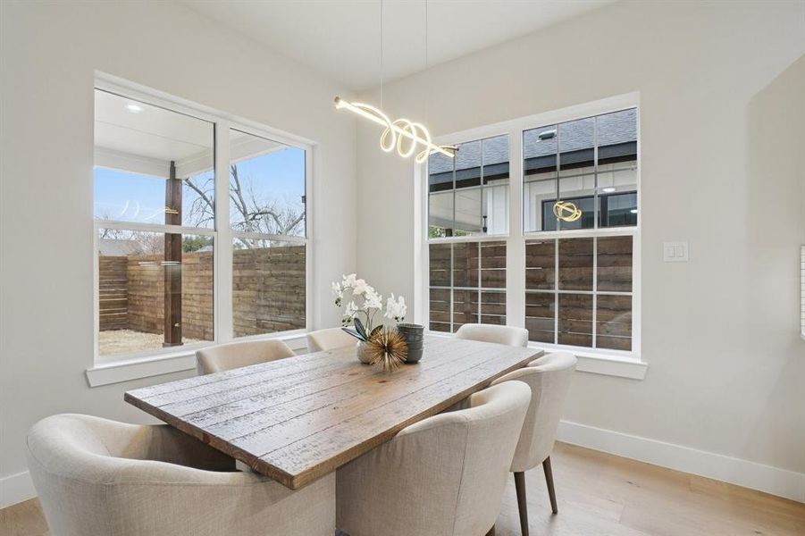 Dining area with light wood-type flooring and a chandelier