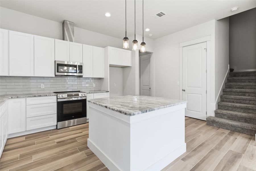 Kitchen with views of stairs to second level and pantry door