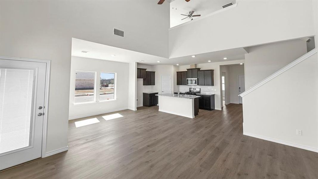 Unfurnished living room with a ceiling fan and dark wood-style floors