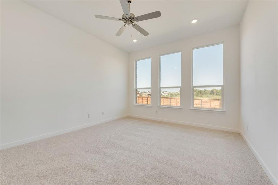 Carpeted spare room with ceiling fan