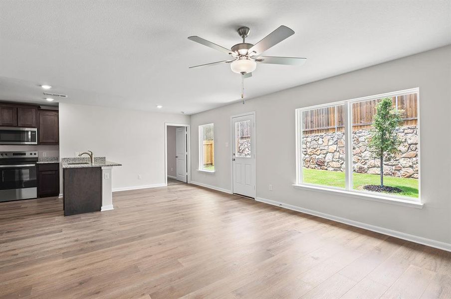 Unfurnished living room featuring a ceiling fan, light wood finished floors, and recessed lighting