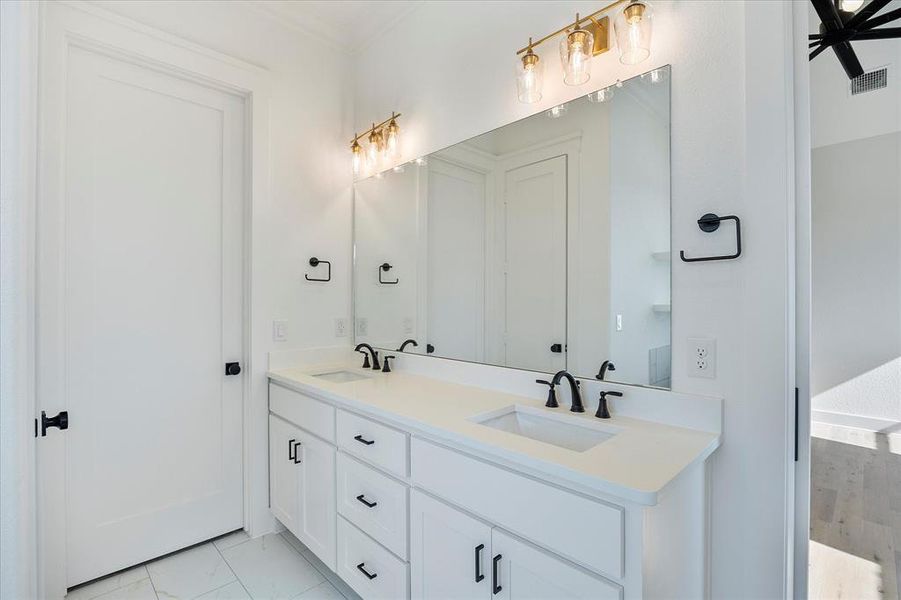 Bathroom featuring double vanity and ornamental molding Bathroom featuring double vanity and ornamental molding