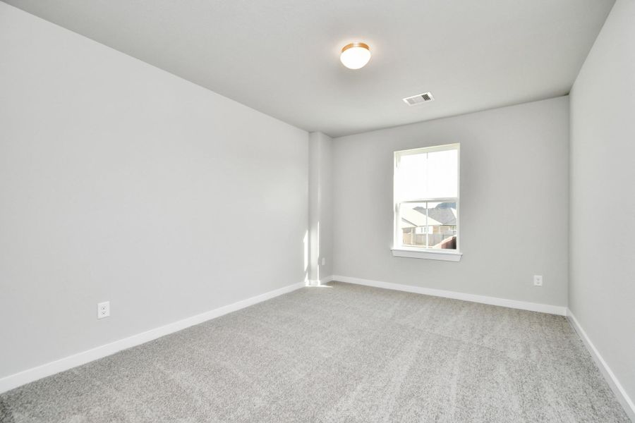 Generously sized secondary bedrooms featuring spacious closets, soft and inviting carpeting underfoot, large windows allowing plenty of natural light, and the added touch of privacy blinds for your personal retreat. Sample photo of completed home with similar floor plan. As-built interior colors and selections may vary.