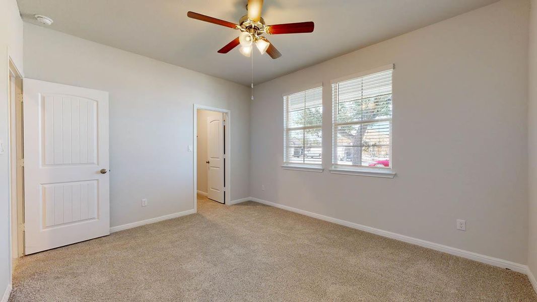 Unfurnished bedroom featuring light carpet and ceiling fan