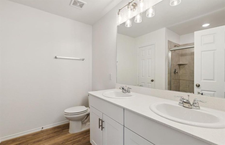 Elegant owner's bathroom with dual vanity and oversized shower*real home pictured