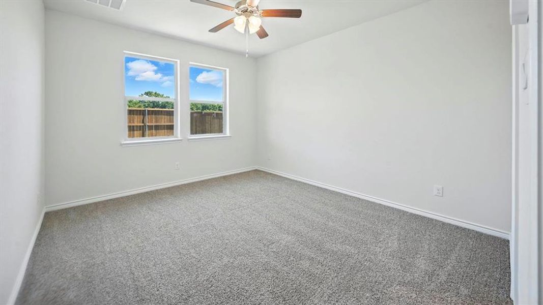 Carpeted empty room with baseboards and ceiling fan