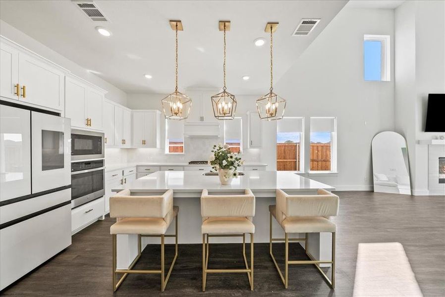 Kitchen featuring visible vents, light countertops, stainless steel oven, and built in microwave