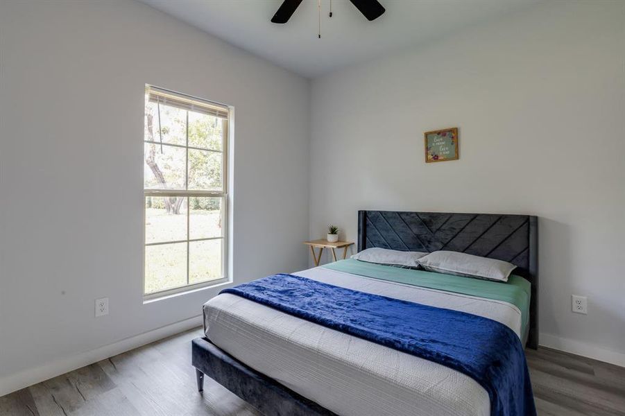 Bedroom with wood finished floors and ceiling fan Bedroom with wood finished floors and ceiling fan