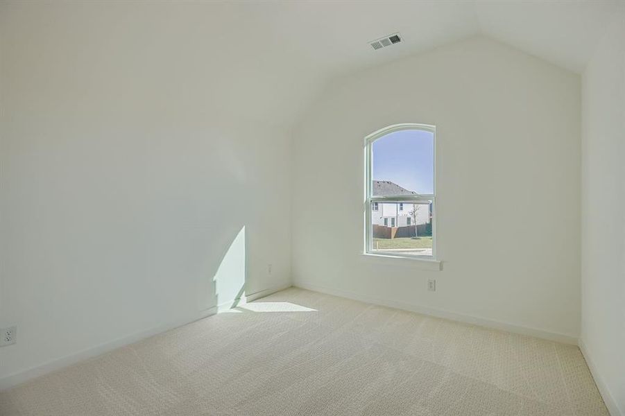 Empty room featuring carpet floors and lofted ceiling Empty room featuring carpet floors and lofted ceiling