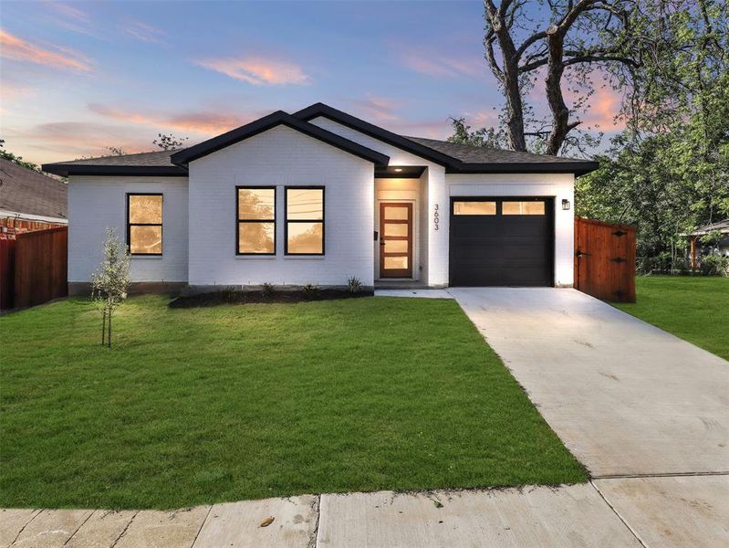 View of front of home featuring concrete driveway, a shingled roof, an attached garage, fence, and a yard View of front of home featuring concrete driveway, a shingled roof, an attached garage, fence, and a yard