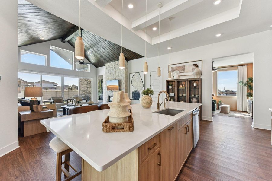 Rich wood floors and a soaring beamed ceiling define this open, light-filled layout.