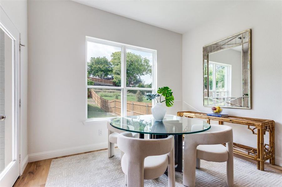 Dining space with a healthy amount of sunlight and light hardwood / wood-style floors