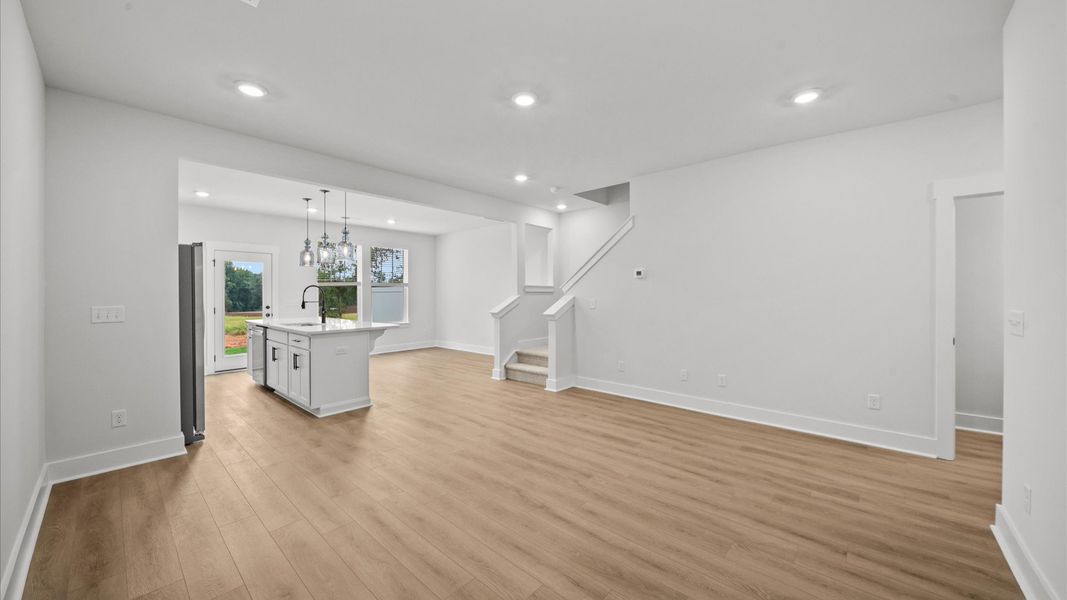 Spacious family room with rich hardwood flooring and elegant trim work in a reputable DRB Homes build