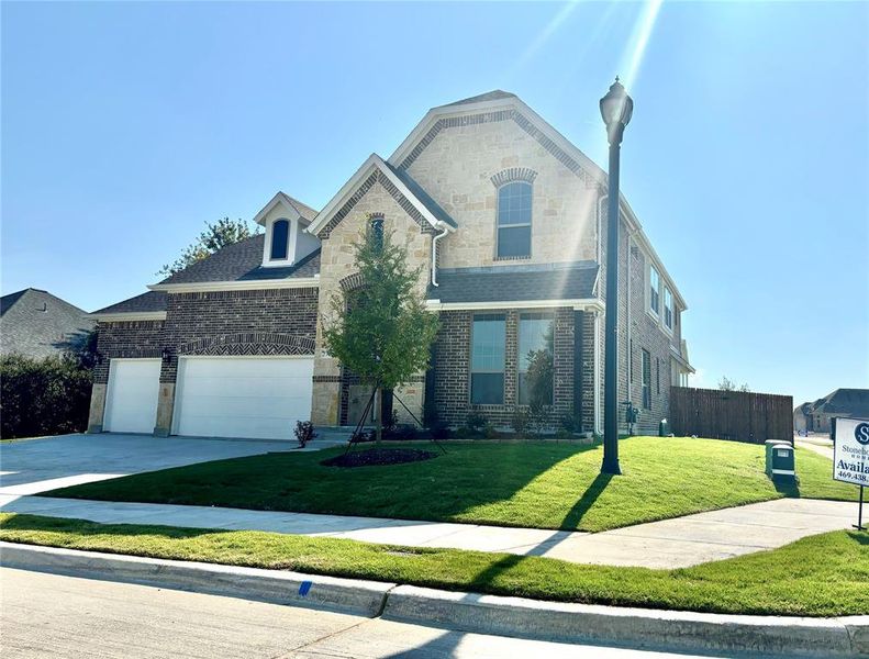 View of front property featuring a garage and a front lawn