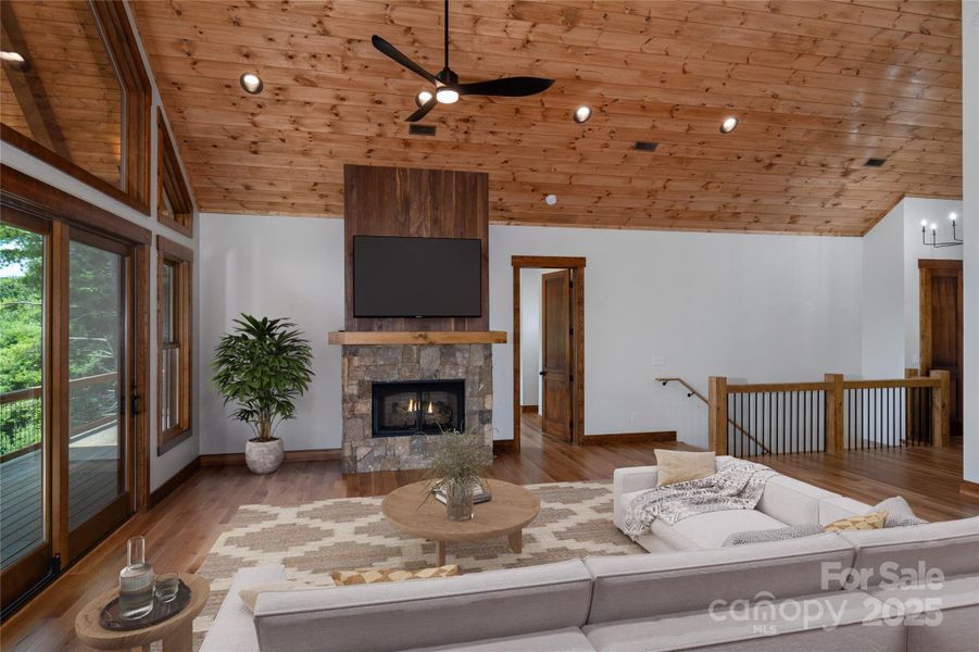 Vaulted living room with floor to ceiling sliding doors & windows and gas fireplace