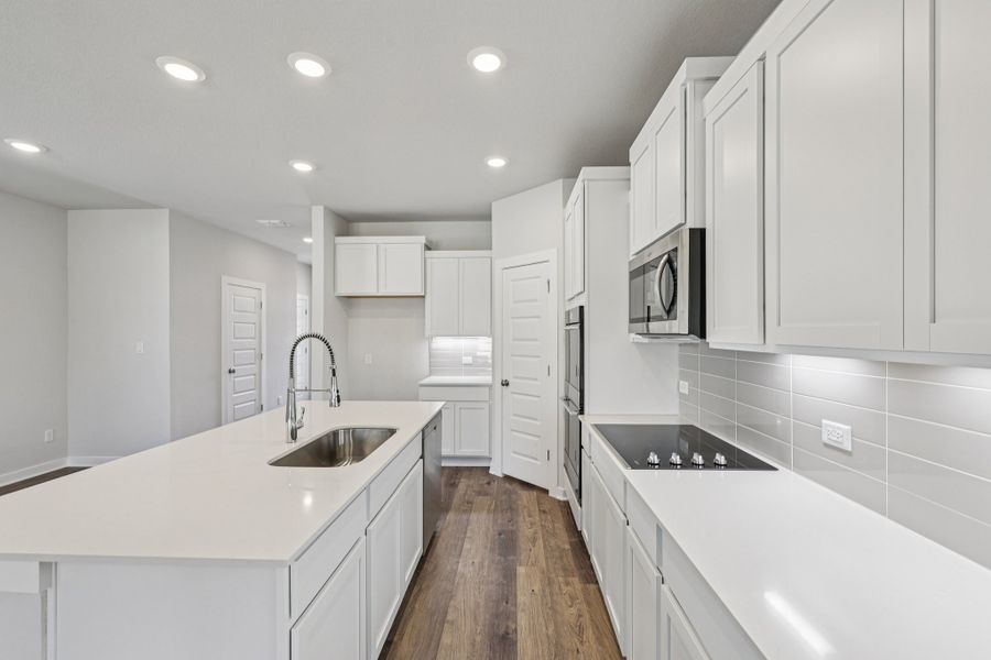 A kitchen with white cabinets.