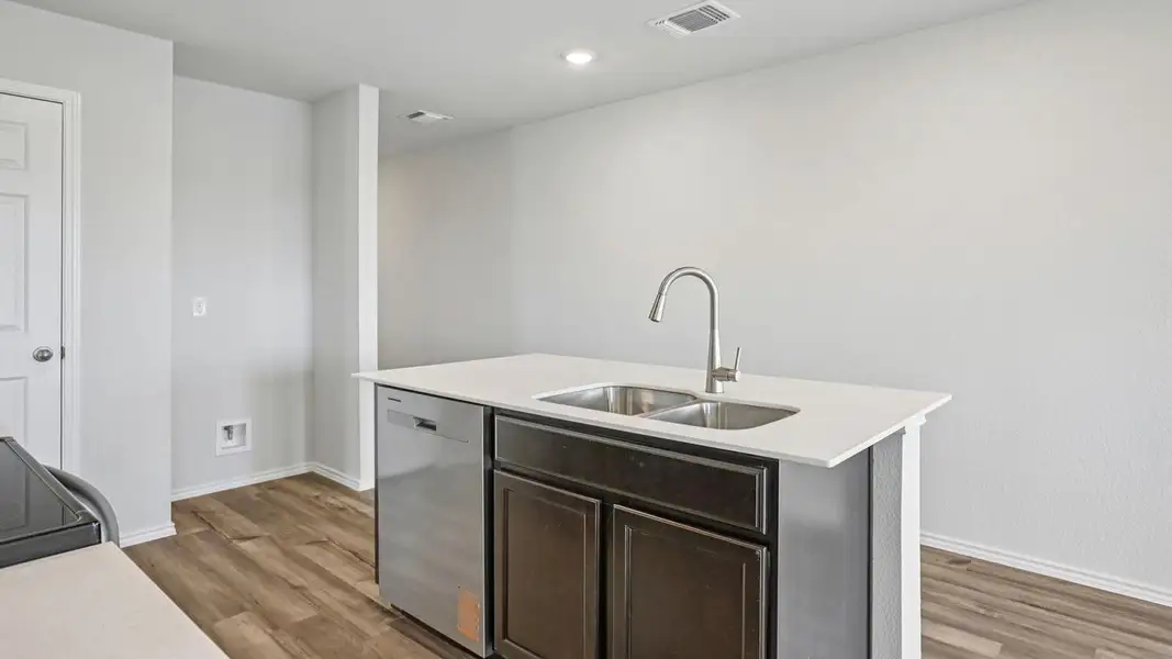 A sleek kitchen island provides functional workspace with an integrated double sink and modern dishwasher. A sleek kitchen island provides functional workspace with an integrated double sink and modern dishwasher.