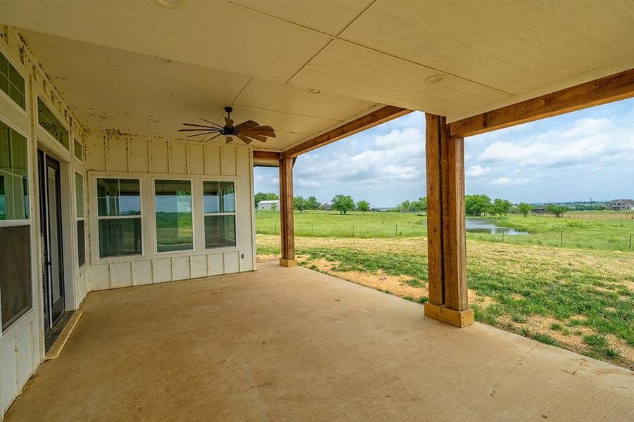 View of patio / terrace featuring a ceiling fan, a water view, and a view of countryside