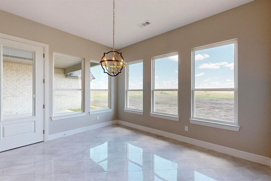 Unfurnished dining area with light tile patterned floors and an inviting chandelier