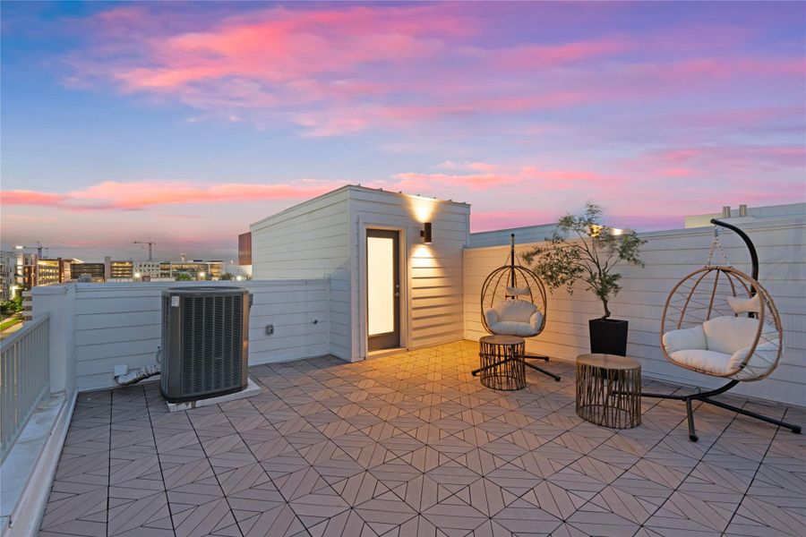 Expansive rooftop deck featuring geometric tile flooring and a privacy wall