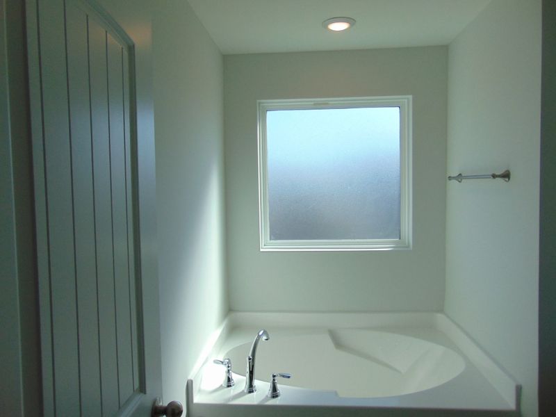The primary bathroom has a soak in tub and shower, as well as two sinks.