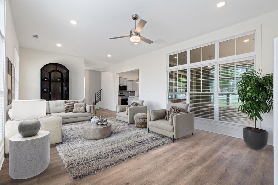 Living area with ceiling fan, wood finished floors, and recessed lighting