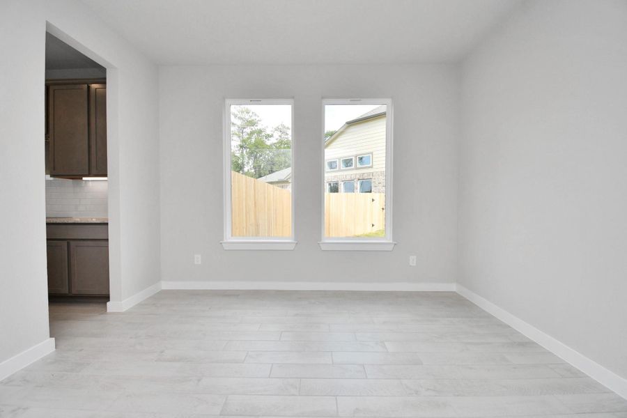 Make memories gathered around the table with your family and friends! This spacious dining room features elegant flooring, custom paint, and adjacent to family room and kitchen for open concept feel. Sample photo of completed home with similar floor plan. Actual colors and selections may vary.