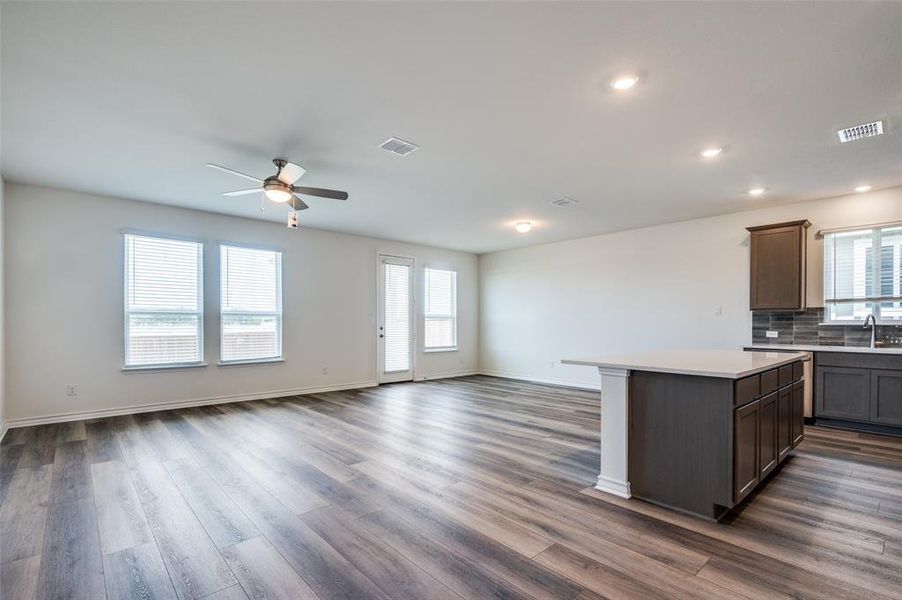 Kitchen with open floor plan, ceiling fan, dark wood-type flooring, light countertops, and recessed lighting Kitchen with open floor plan, ceiling fan, dark wood-type flooring, light countertops, and recessed lighting