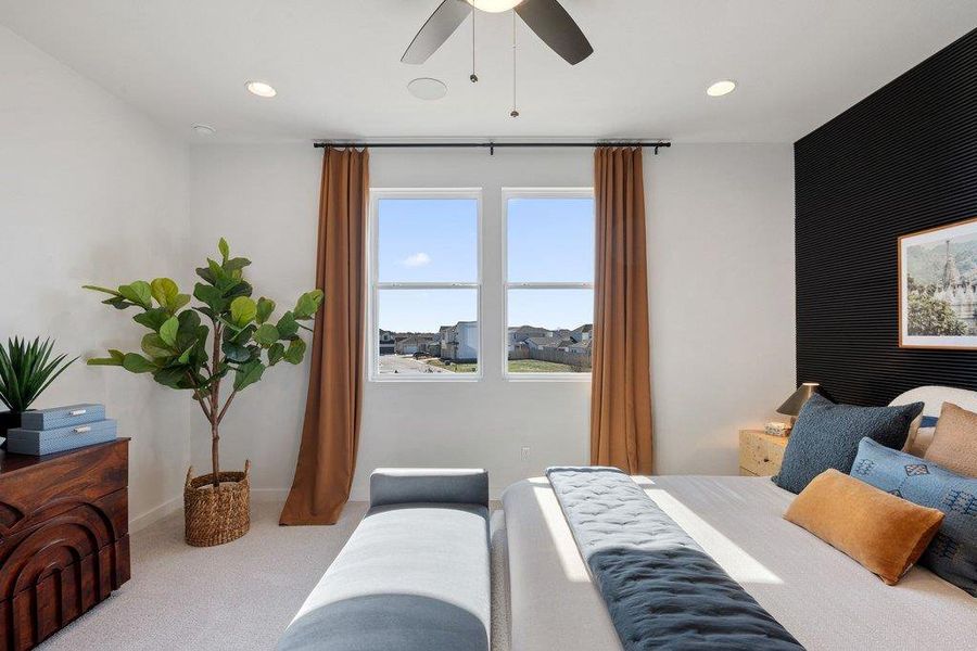 Bedroom featuring a black accent wall with horizontal paneling, two windows with dark curtain rods, recessed lighting, and a ceiling fan with integrated lighting