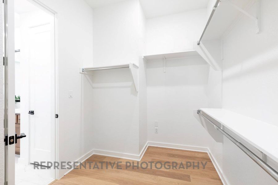 Spacious closet featuring light wood-style floors Spacious closet featuring light wood-style floors