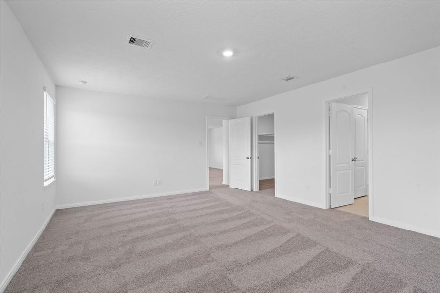 Additional view from primary suite to walk-in closet and primary bathroom