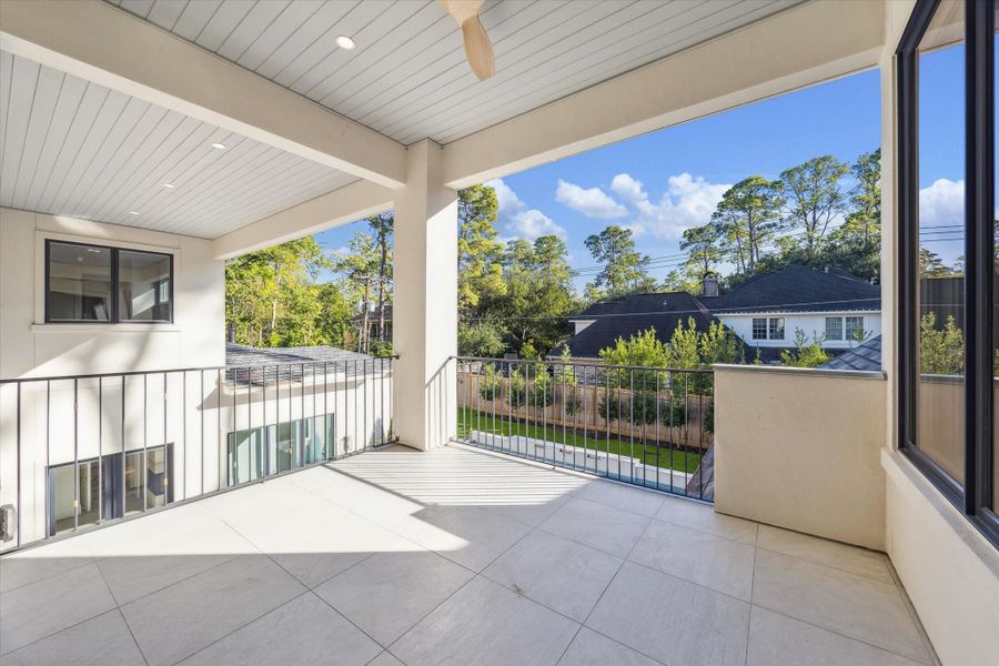 Expansive covered balcony on the second floor, complete with recessed lighting and a ceiling fan, overlooking the picturesque backyard. Generously sized to accommodate relaxed gatherings and evening unwinding.