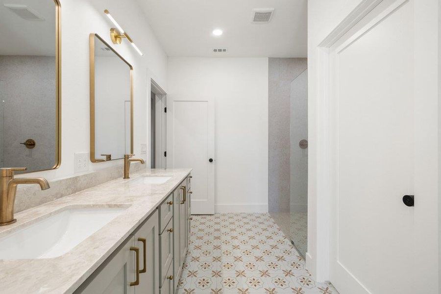 Bathroom with walk in shower, double vanity, light floors, and recessed lighting