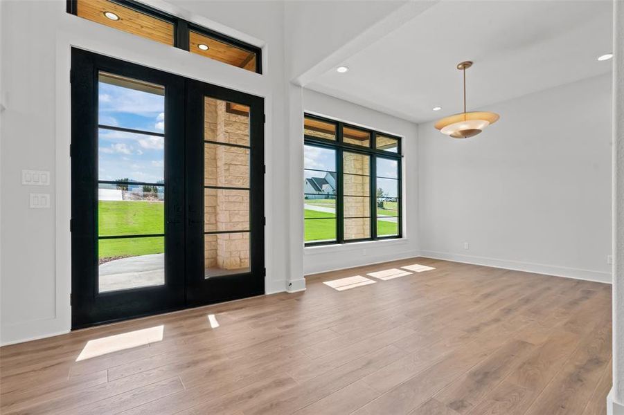 Foyer with french doors, wood finished floors, and recessed lighting